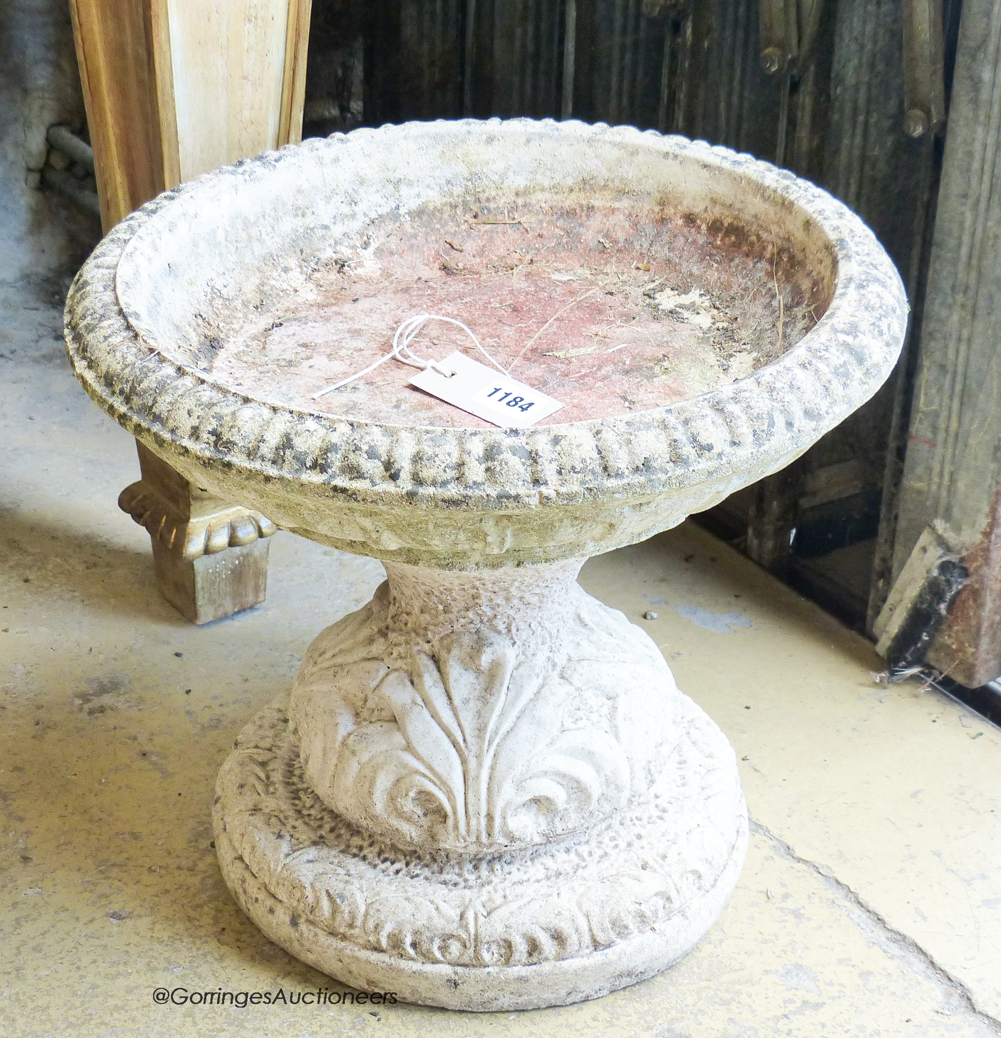 A circular reconstituted stone garden bird bath, diameter 38cm, height 34cm